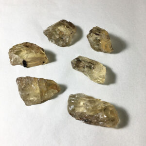 Six small pieces of Golden Labradorite rough rock on a white seamless background.