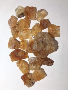 Pieces of Hyalite Opal rough rock. Pieces average one to two inches in size and are clear and orange in color.