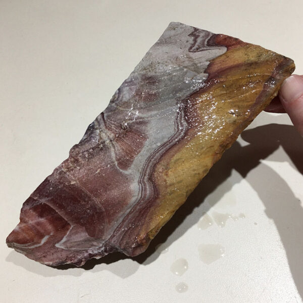 1.52 pound piece of Mexican Rhyolite rough rock, pictured wet. Side one of six sides.