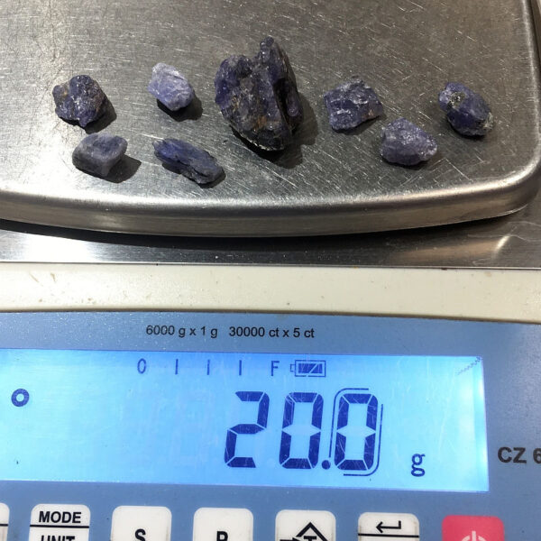 Eight small pieces of Tanzanite rough rock on a scale. Combined weight is 20 grams.