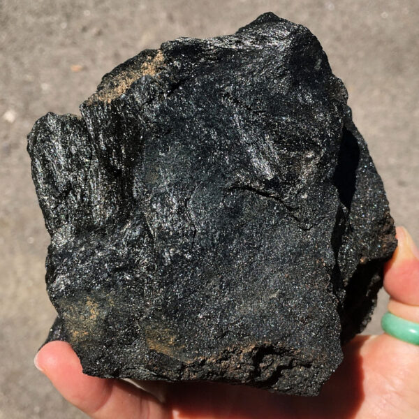 3.08 pound piece of Velvet Black Tourmaline rough rock pictured in sunlight. Side three of six sides.