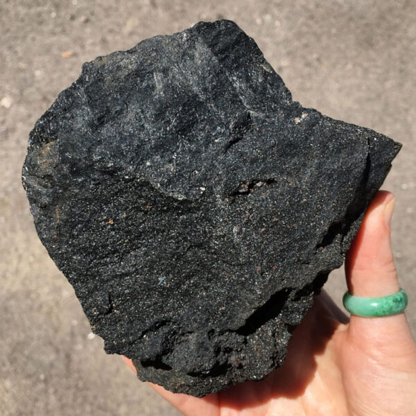 3.08 pound piece of Velvet Black Tourmaline rough rock pictured in sunlight. Side four of six sides.