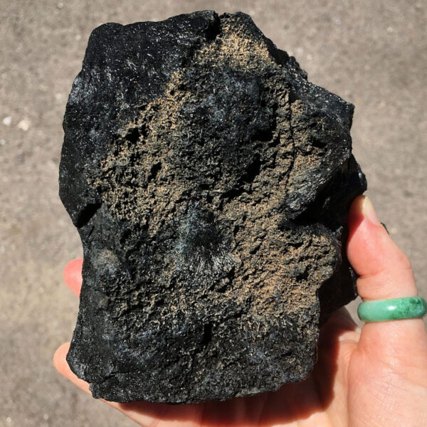 3.08 pound piece of Velvet Black Tourmaline rough rock pictured in sunlight. Side five of six sides.