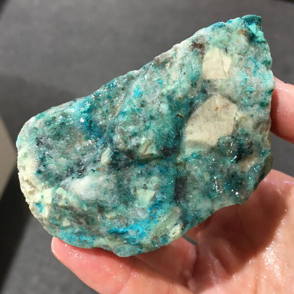 0.70 pound piece of Teal Turq Rhyolite rough rock, pictured wet. Side two of five sides.