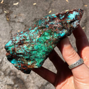 1.10 pound piece of Teal Turq Rhyolite rough rock, pictured wet. Side one of six sides.