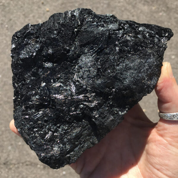 1.70 pound piece of Velvet Black Tourmaline rough rock, pictured dry in sunlight. Side one of five sides.