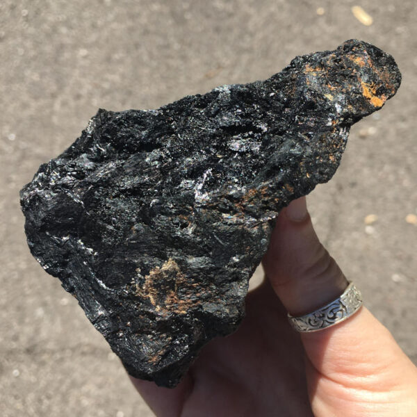 1.70 pound piece of Velvet Black Tourmaline rough rock, pictured dry in sunlight. Side two of five sides.