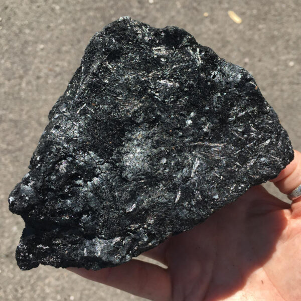 1.70 pound piece of Velvet Black Tourmaline rough rock, pictured dry in sunlight. Side three of five sides.