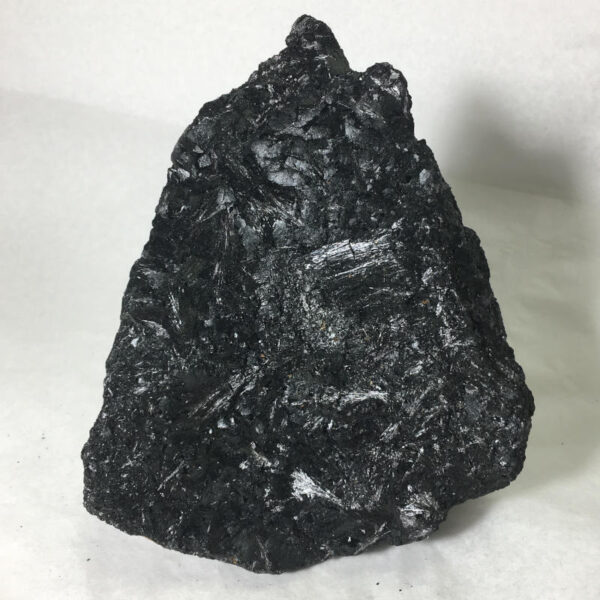 1.70 pound piece of Velvet Black Tourmaline rough rock, pictured dry on a white background