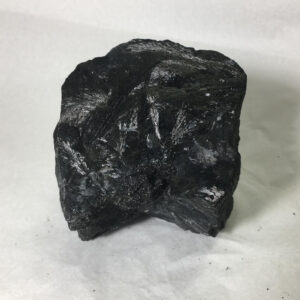 1.80 pound piece of Velvet Black Tourmaline rough rock, pictured dry on a white background.