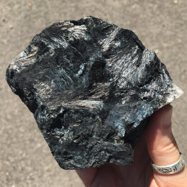 1.80 pound piece of Velvet Black Tourmaline rough rock, pictured dry in the sunlight. Side six of six sides.