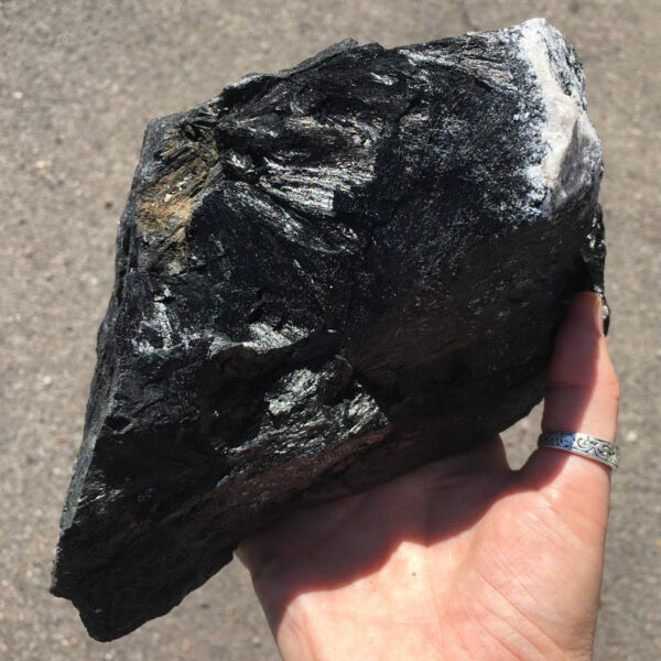 5.22 pound piece of Velvet Black Tourmaline rough rock, pictured dry in the sunlight. Side one of six sides.