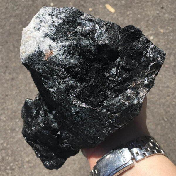 5.22 pound piece of Velvet Black Tourmaline rough rock, pictured dry in the sunlight. Side two of six sides.