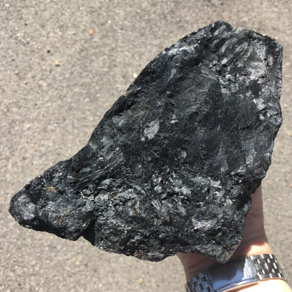 5.22 pound piece of Velvet Black Tourmaline rough rock, pictured dry in the sunlight. Side four of six sides.