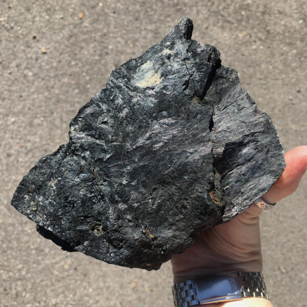 5.22 pound piece of Velvet Black Tourmaline rough rock, pictured dry in the sunlight. Side five of six sides.