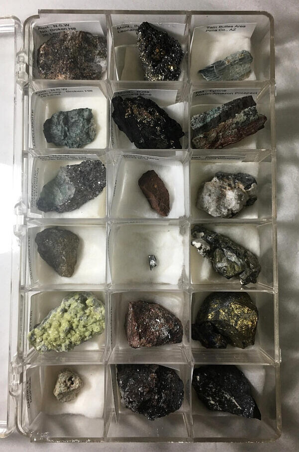 Open plastic 18-compartment mineral specimen case with minerals in it.